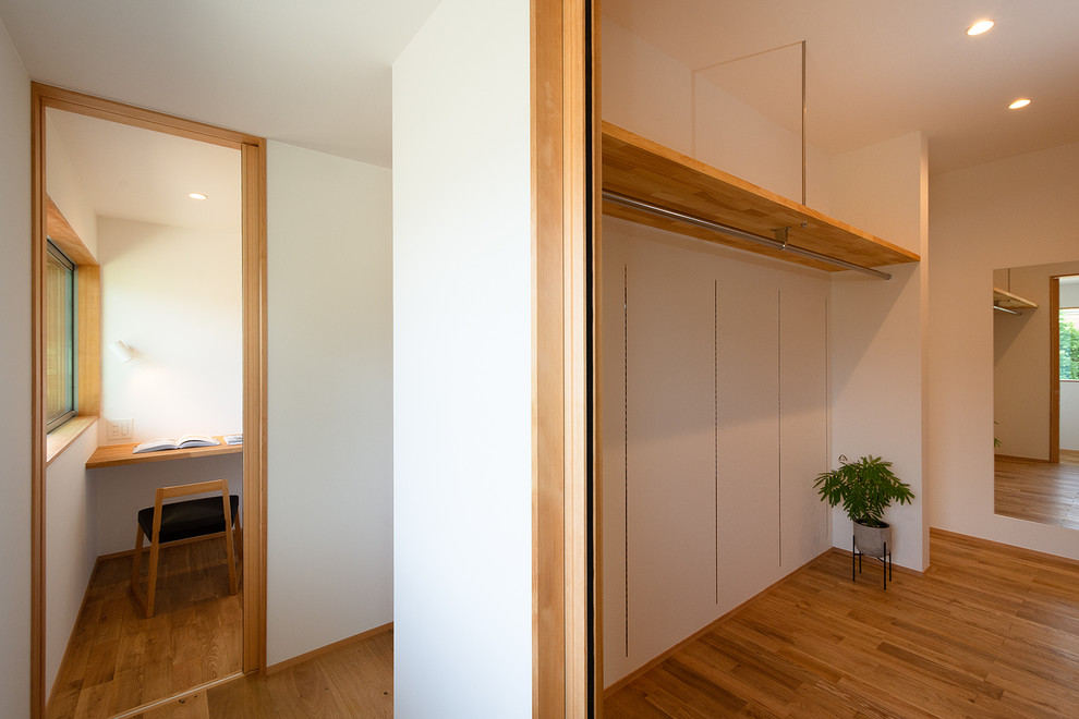 Ispirazione per una cabina armadio unisex scandinava di medie dimensioni con nessun'anta, pavimento in legno massello medio, pavimento beige e soffitto in carta da parati