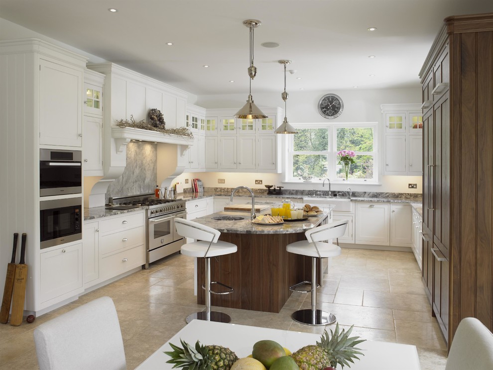 Design ideas for a large transitional u-shaped eat-in kitchen in Essex with granite benchtops, limestone floors, with island, white cabinets, grey splashback, stainless steel appliances, beige floor, a farmhouse sink, shaker cabinets and stone slab splashback.