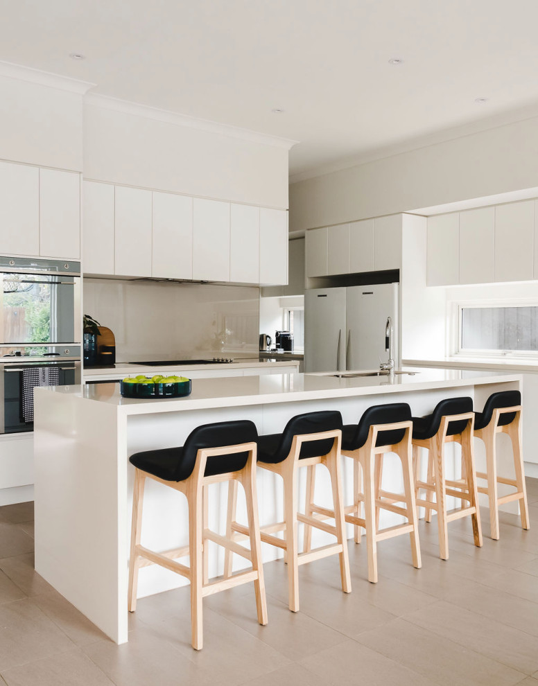Contemporary kitchen in Melbourne with an undermount sink, flat-panel cabinets, white cabinets, beige splashback, stone slab splashback, with island, beige floor and beige benchtop.