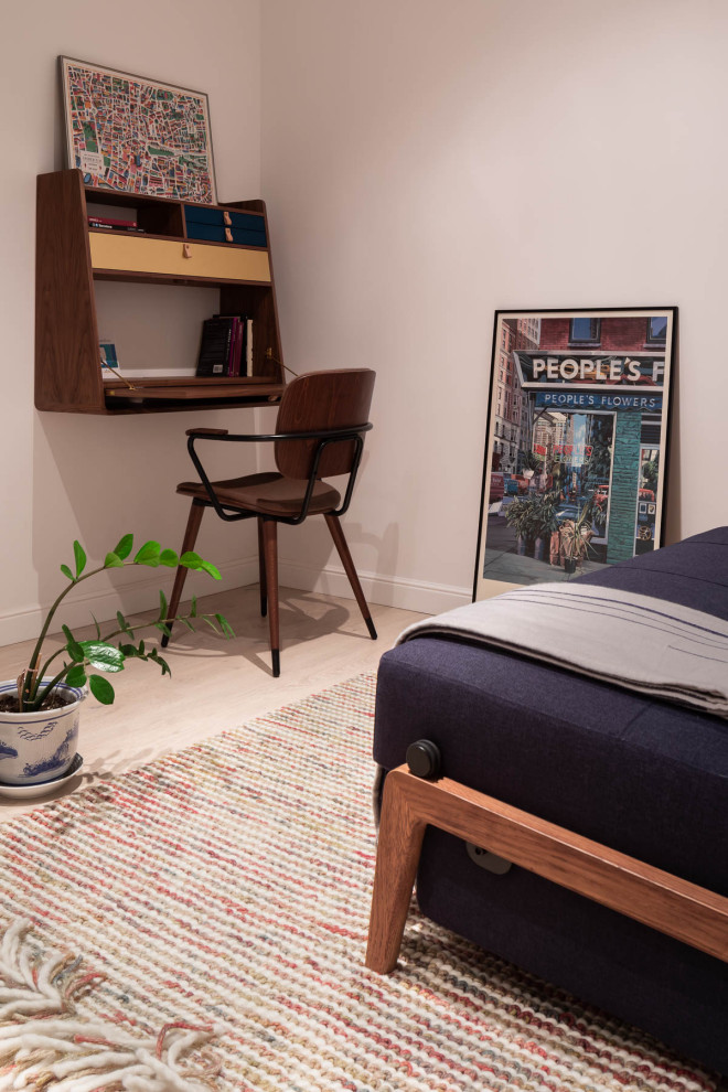Photo of a small eclectic study room in Barcelona with white walls, light hardwood floors and a freestanding desk.