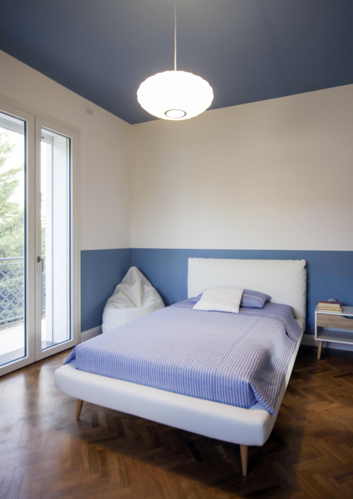 Ejemplo de dormitorio infantil bohemio extra grande con paredes azules, suelo de madera oscura y boiserie
