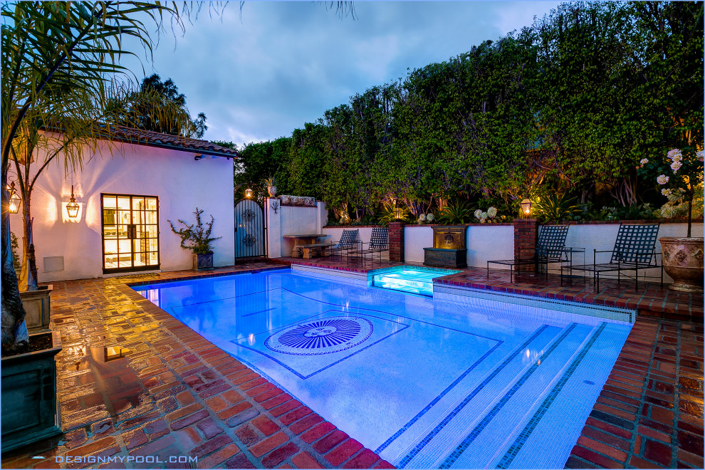 Ejemplo de piscina elevada retro de tamaño medio rectangular en patio trasero con adoquines de ladrillo