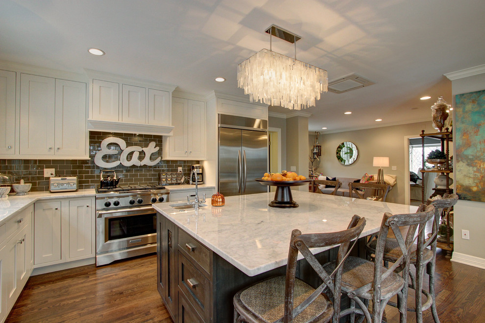 Large transitional l-shaped dark wood floor enclosed kitchen photo in Denver with an undermount sink, shaker cabinets, white cabinets, marble countertops, brown backsplash, subway tile backsplash, stainless steel appliances and an island