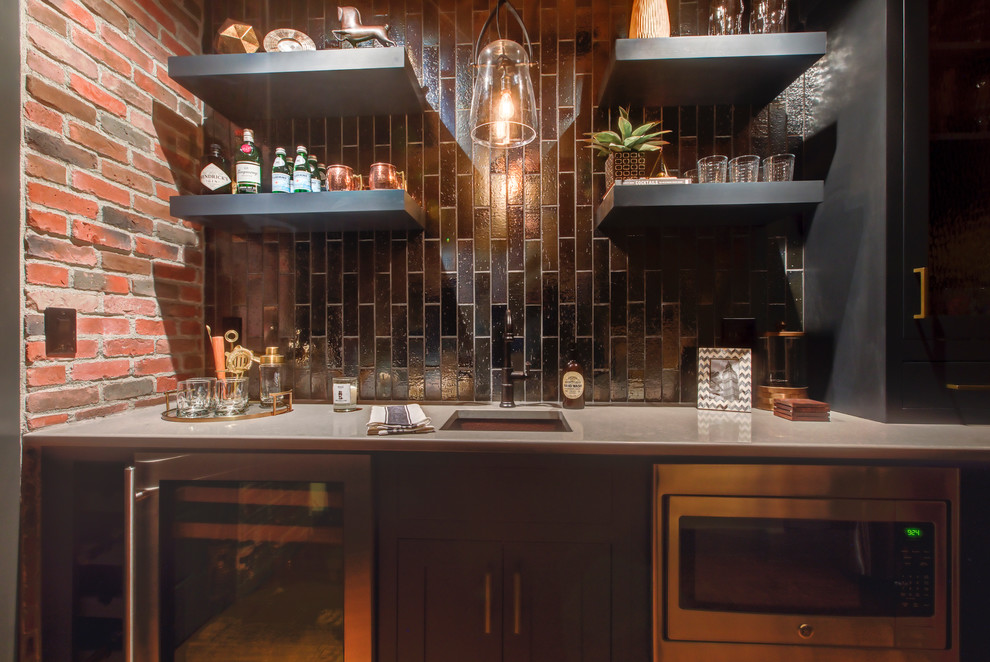 This is an example of a small industrial single-wall wet bar in Raleigh with an undermount sink, recessed-panel cabinets, black cabinets, quartz benchtops, black splashback, ceramic splashback, dark hardwood floors and brown floor.