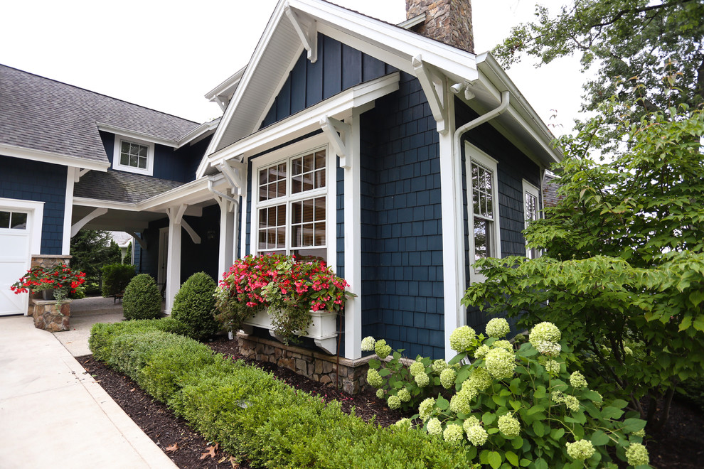 This is an example of a mid-sized beach style one-storey blue house exterior in Indianapolis with wood siding, a gable roof and a shingle roof.