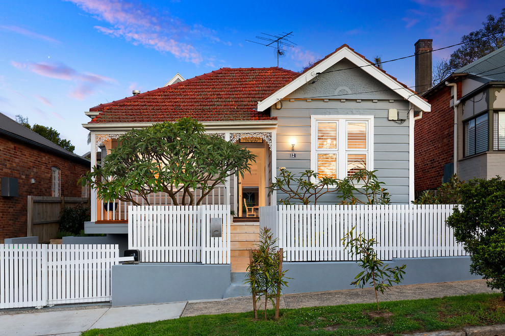 Inspiration for a mid-sized traditional one-storey grey house exterior in Sydney with a gable roof and a tile roof.