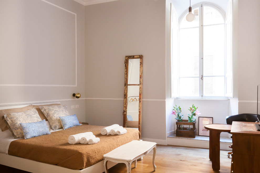 ローマにあるコンテンポラリースタイルのおしゃれな主寝室 (グレーの壁、淡色無垢フローリング)