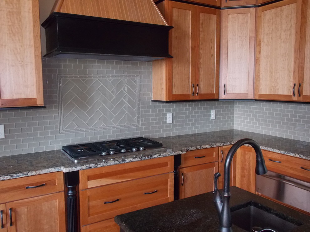 Example of a transitional kitchen design with medium tone wood cabinets, quartzite countertops and an island