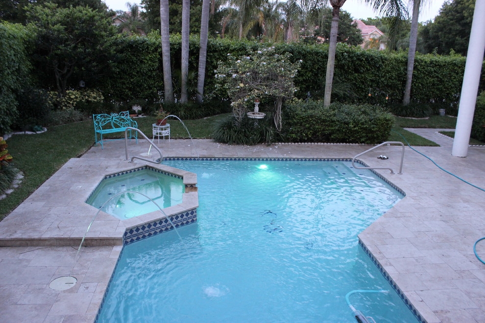 Transitional backyard custom-shaped pool photo in Miami with decking