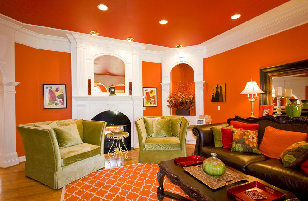 Inspiration for a traditional living room in Other with orange walls, medium hardwood floors and a standard fireplace.