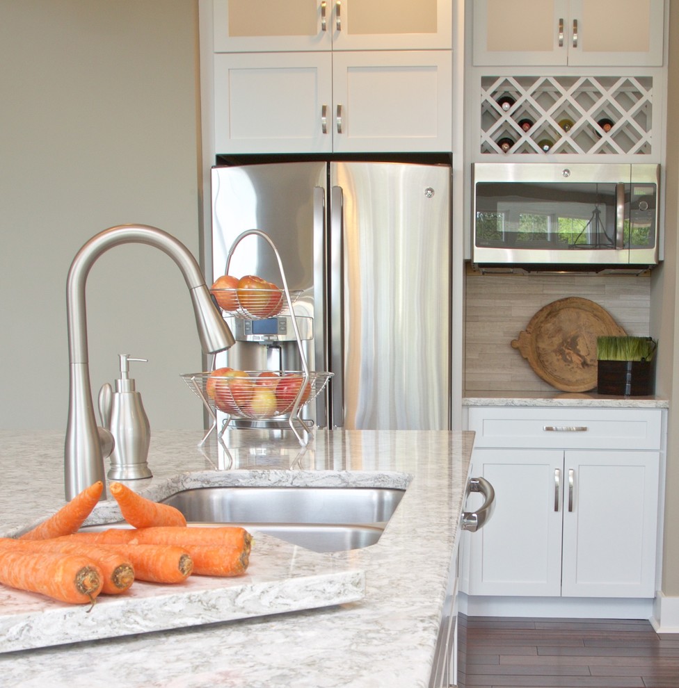 Inspiration for a mid-sized transitional galley eat-in kitchen remodel with white cabinets, granite countertops, beige backsplash, stone tile backsplash and stainless steel appliances