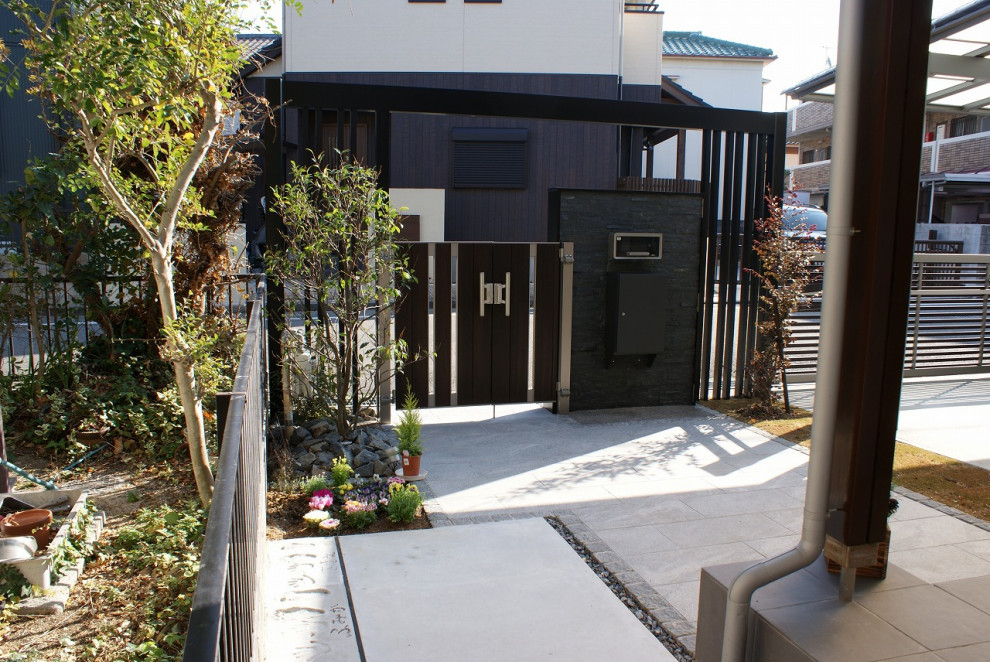 Foto di un vialetto d'ingresso esposto in pieno sole di medie dimensioni e davanti casa in inverno con cancello, pavimentazioni in pietra naturale e recinzione in metallo