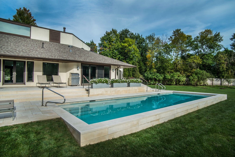 Inspiration for a mid-sized modern backyard rectangular lap pool in Chicago with a hot tub and natural stone pavers.