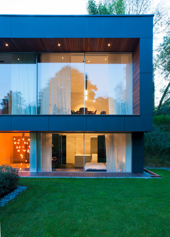 Large modern two-storey stucco white house exterior in Frankfurt with a flat roof and a green roof.