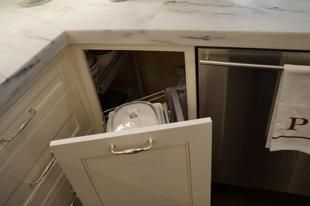Large transitional u-shaped medium tone wood floor and brown floor eat-in kitchen photo in Boston with an undermount sink, recessed-panel cabinets, white cabinets, marble countertops, white backsplash, stone slab backsplash, stainless steel appliances, two islands and white countertops