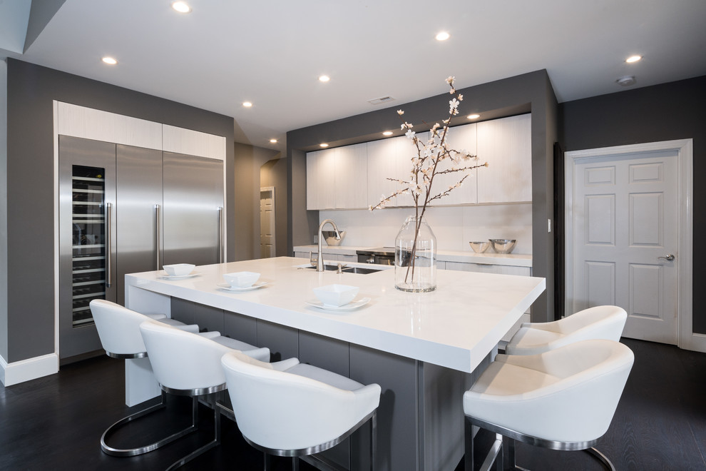Photo of a mid-sized contemporary l-shaped eat-in kitchen in Atlanta with an undermount sink, flat-panel cabinets, grey cabinets, quartz benchtops, white splashback, stainless steel appliances, dark hardwood floors, with island, black floor and white benchtop.