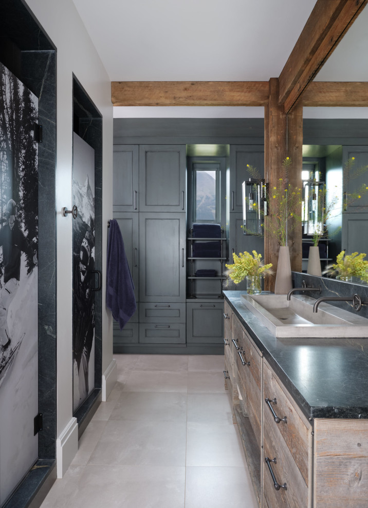 Bathroom - rustic kids' beige floor and double-sink bathroom idea with light wood cabinets, white walls, a trough sink and black countertops