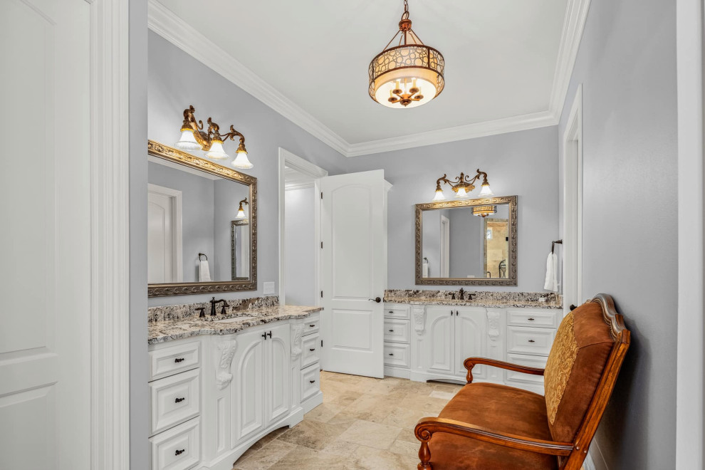 Photo of a large traditional master bathroom in Other with raised-panel cabinets, white cabinets, a corner tub, a double shower, a two-piece toilet, travertine, grey walls, travertine floors, an undermount sink, granite benchtops, beige floor, a hinged shower door, beige benchtops, an enclosed toilet, a double vanity and a built-in vanity.
