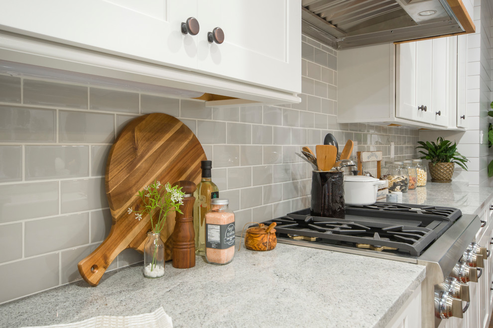 Open concept kitchen - large contemporary galley dark wood floor and brown floor open concept kitchen idea in St Louis with a double-bowl sink, flat-panel cabinets, white cabinets, marble countertops, black appliances, an island and white countertops