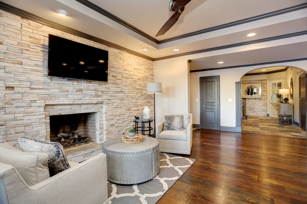 This is an example of a large transitional walk-out basement in Atlanta with grey walls, a standard fireplace, a stone fireplace surround, dark hardwood floors and brown floor.
