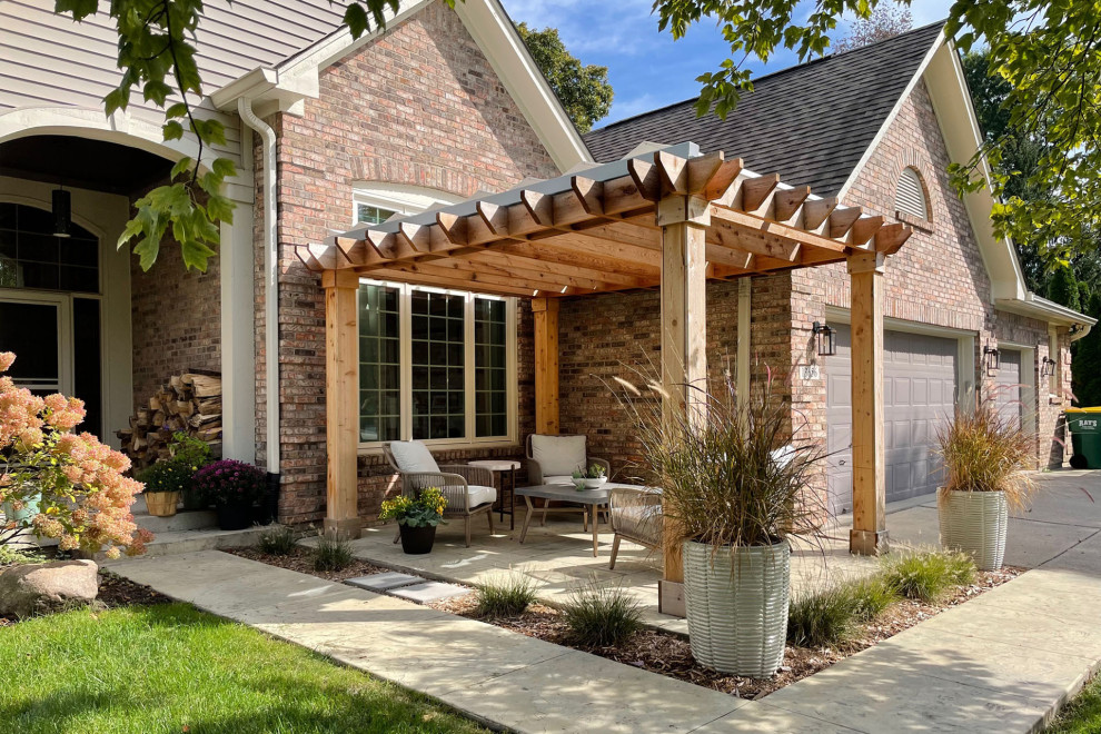 Example of a beach style front yard concrete patio design in Indianapolis with a pergola