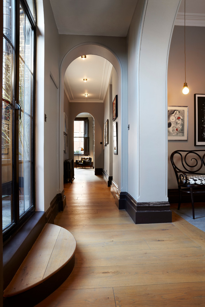 Design ideas for a traditional hallway in London with white walls, orange floor and light hardwood floors.