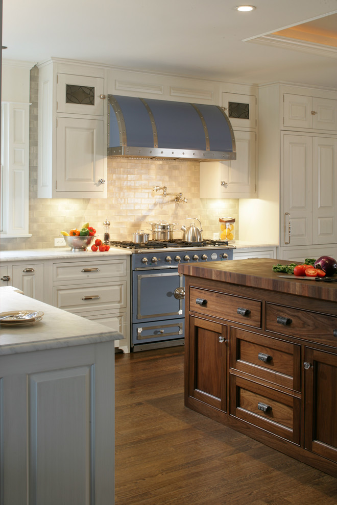Elegant l-shaped eat-in kitchen photo in New York with a farmhouse sink, raised-panel cabinets, white cabinets, marble countertops, gray backsplash, ceramic backsplash and colored appliances