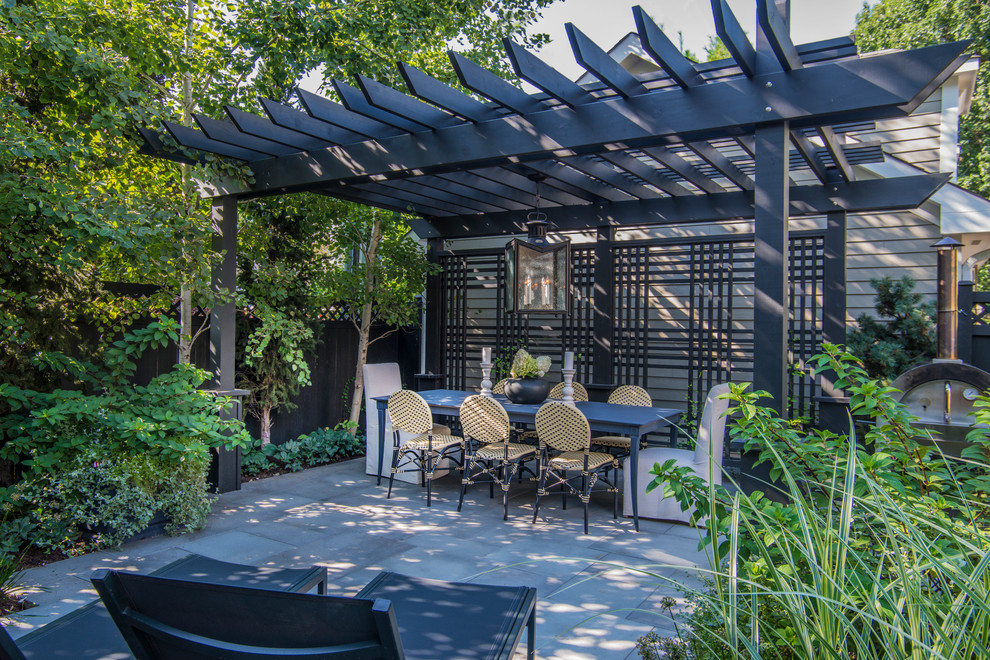Photo of a small contemporary backyard patio in Chicago with natural stone pavers and a pergola.