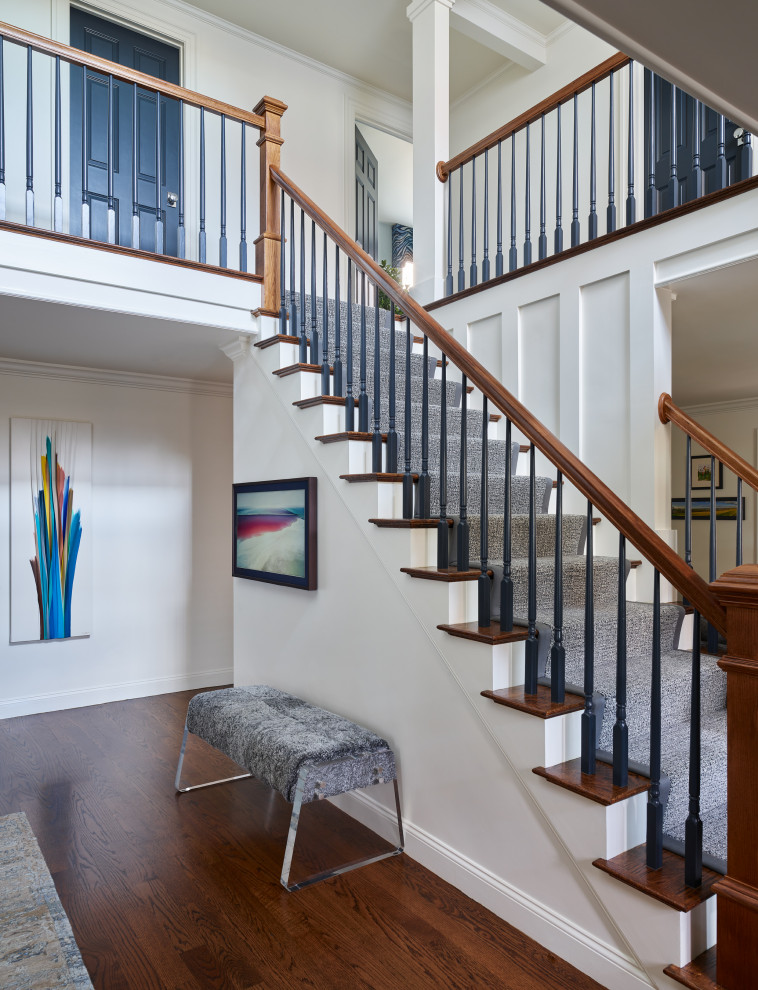 This is an example of a large transitional wood straight staircase in Boston with wood risers, mixed railing and decorative wall panelling.