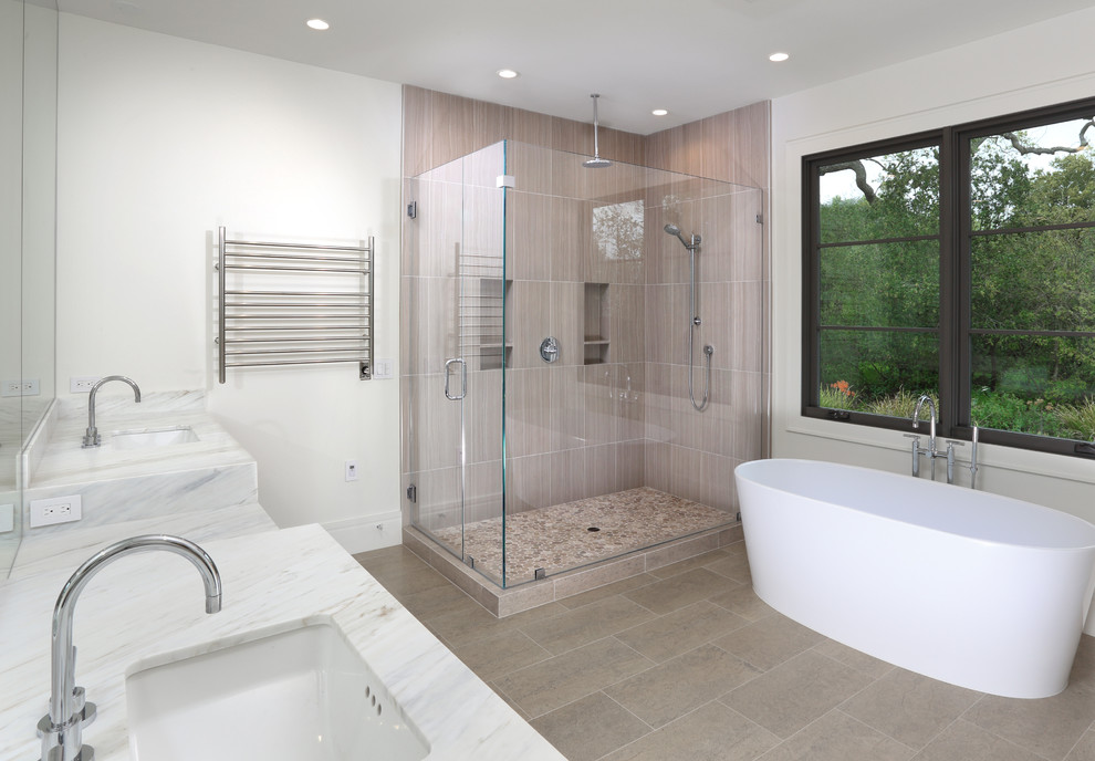 Large contemporary master bathroom in San Francisco with a freestanding tub, a double shower, beige tile, stone tile, white walls and an undermount sink.