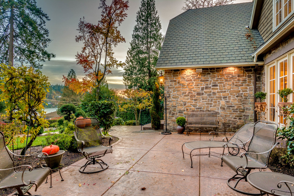 This is an example of a mid-sized traditional patio in Portland with stamped concrete and no cover.