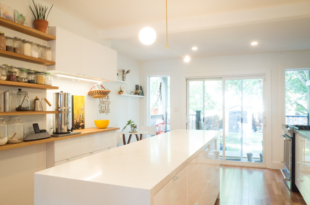 This is an example of a mid-sized scandinavian single-wall eat-in kitchen in Toronto with an undermount sink, open cabinets, white cabinets, quartz benchtops, white splashback, ceramic splashback, stainless steel appliances, light hardwood floors and with island.