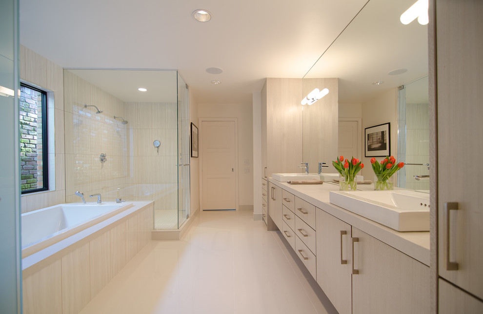 Photo of a mid-sized contemporary master bathroom in Dallas with flat-panel cabinets, light wood cabinets, a drop-in tub, a double shower, beige tile, porcelain tile, white walls, porcelain floors, a drop-in sink, engineered quartz benchtops, beige floor and a hinged shower door.