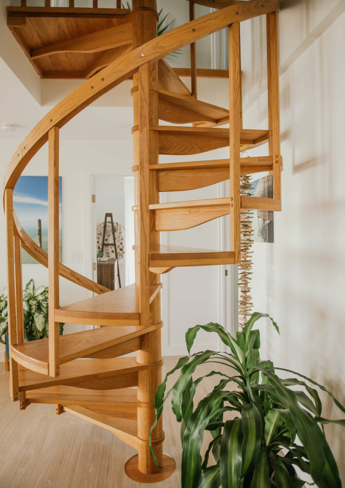 Small beach style wood spiral staircase in Other with wood risers and wood railing.