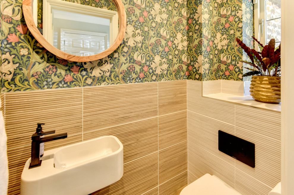 Kleine Moderne Gästetoilette mit Toilette mit Aufsatzspülkasten, beigen Fliesen, Keramikfliesen, bunten Wänden, Keramikboden, Wandwaschbecken, gefliestem Waschtisch, beigem Boden, beiger Waschtischplatte und Tapetenwänden in Sussex