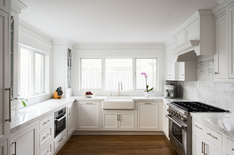 This is an example of a traditional u-shaped eat-in kitchen in Providence with marble benchtops, marble splashback, stainless steel appliances and no island.