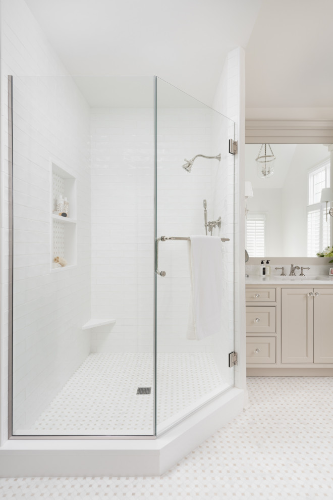 Inspiration for a large traditional ensuite bathroom in Chicago with beaded cabinets, beige cabinets, a freestanding bath, a corner shower, white walls, marble flooring, a submerged sink, engineered stone worktops, beige floors, a hinged door, white worktops, a wall niche, double sinks, a built in vanity unit and a vaulted ceiling.