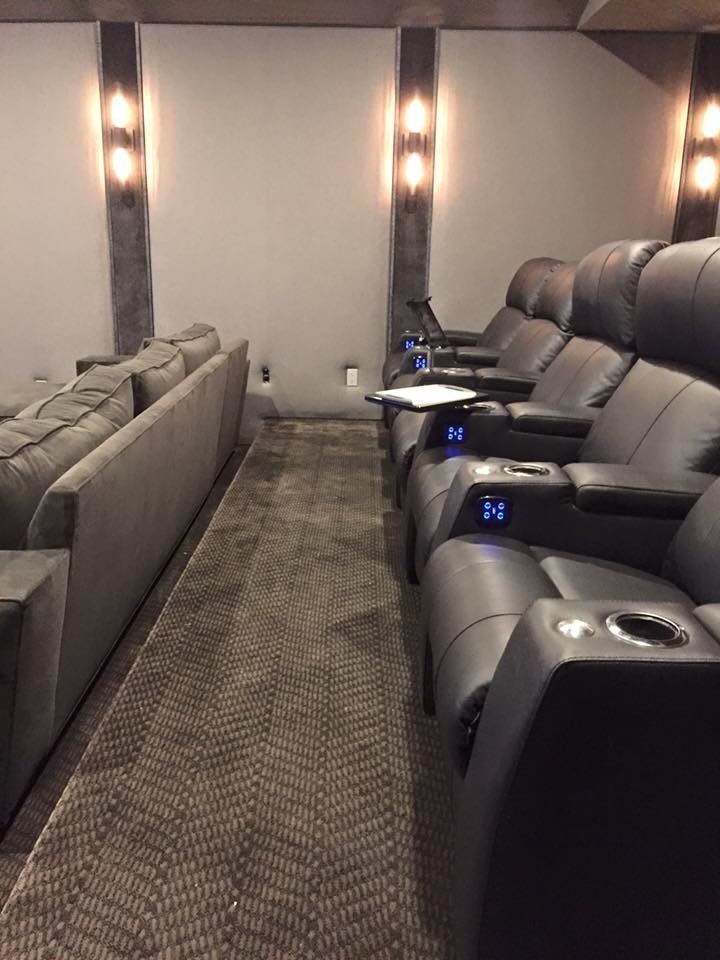 This is an example of a large contemporary enclosed home theatre in Los Angeles with grey walls, carpet, a wall-mounted tv and grey floor.