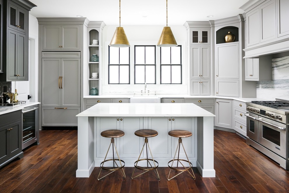 Inspiration for a transitional u-shaped kitchen in Louisville with a farmhouse sink, shaker cabinets, grey cabinets, multi-coloured splashback, stone slab splashback, stainless steel appliances, dark hardwood floors, with island, brown floor and white benchtop.
