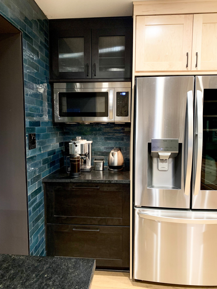 Eat-in kitchen - mid-sized transitional u-shaped light wood floor and brown floor eat-in kitchen idea with an undermount sink, shaker cabinets, light wood cabinets, granite countertops, blue backsplash, ceramic backsplash, stainless steel appliances, a peninsula and black countertops