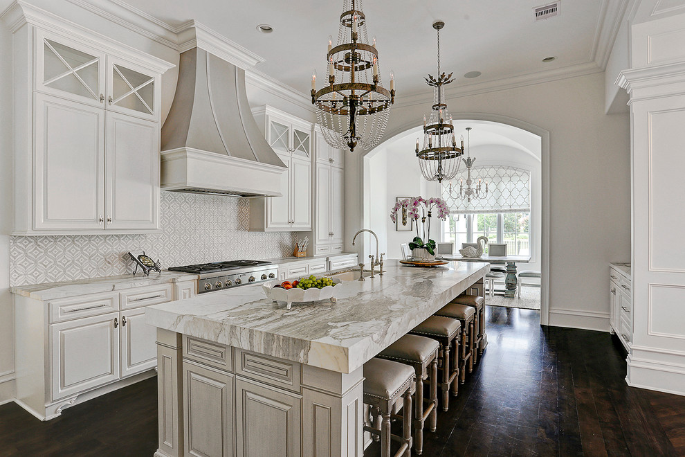 Inspiration for a traditional galley separate kitchen in Houston with an undermount sink, raised-panel cabinets, white cabinets, white splashback, stainless steel appliances, dark hardwood floors, with island and brown floor.