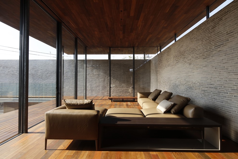 This is an example of a modern living room in Tokyo with grey walls, medium hardwood floors and brown floor.