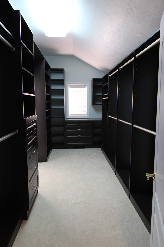 Large traditional walk-in wardrobe in Other with raised-panel cabinets and dark wood cabinets.