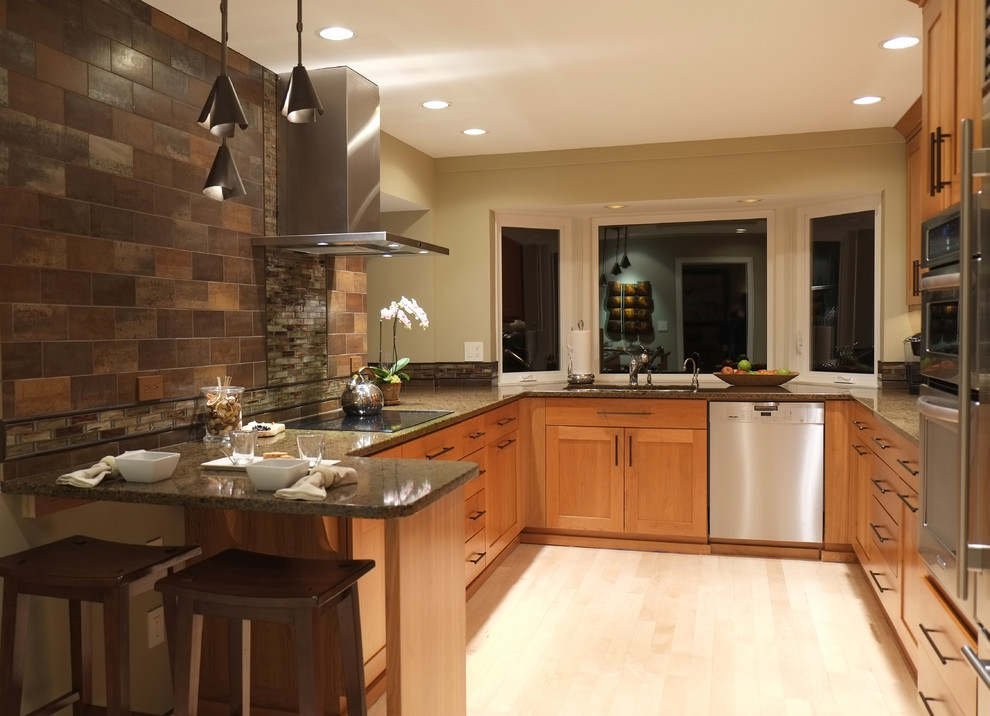 Photo of a mid-sized contemporary u-shaped kitchen in Seattle with shaker cabinets, medium wood cabinets, granite benchtops, multi-coloured splashback, stone tile splashback, a peninsula, a double-bowl sink, stainless steel appliances and light hardwood floors.
