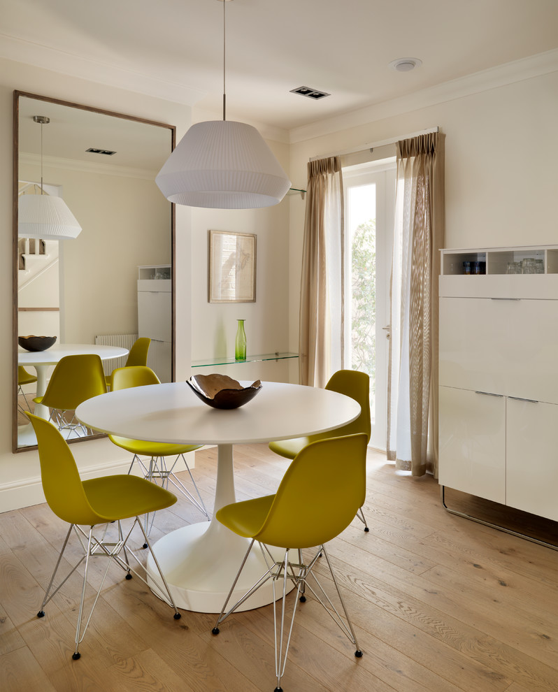 Photo of a contemporary dining room in London with white walls and light hardwood floors.