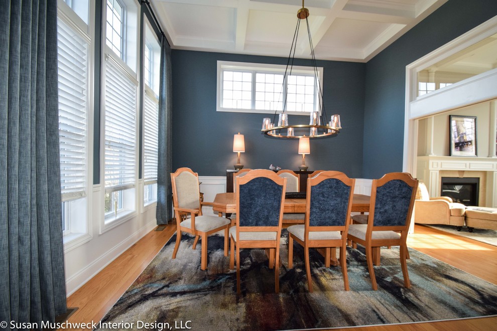 Mid-sized transitional light wood floor enclosed dining room photo with blue walls