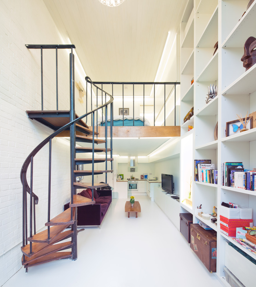 Design ideas for a contemporary wood spiral staircase in London with open risers.