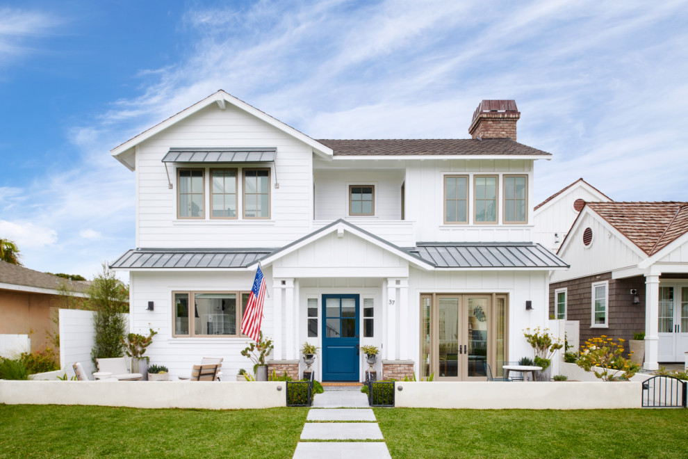 Großes, Zweistöckiges Maritimes Einfamilienhaus mit Vinylfassade, weißer Fassadenfarbe, Satteldach, Schindeldach, braunem Dach und Verschalung in Orange County