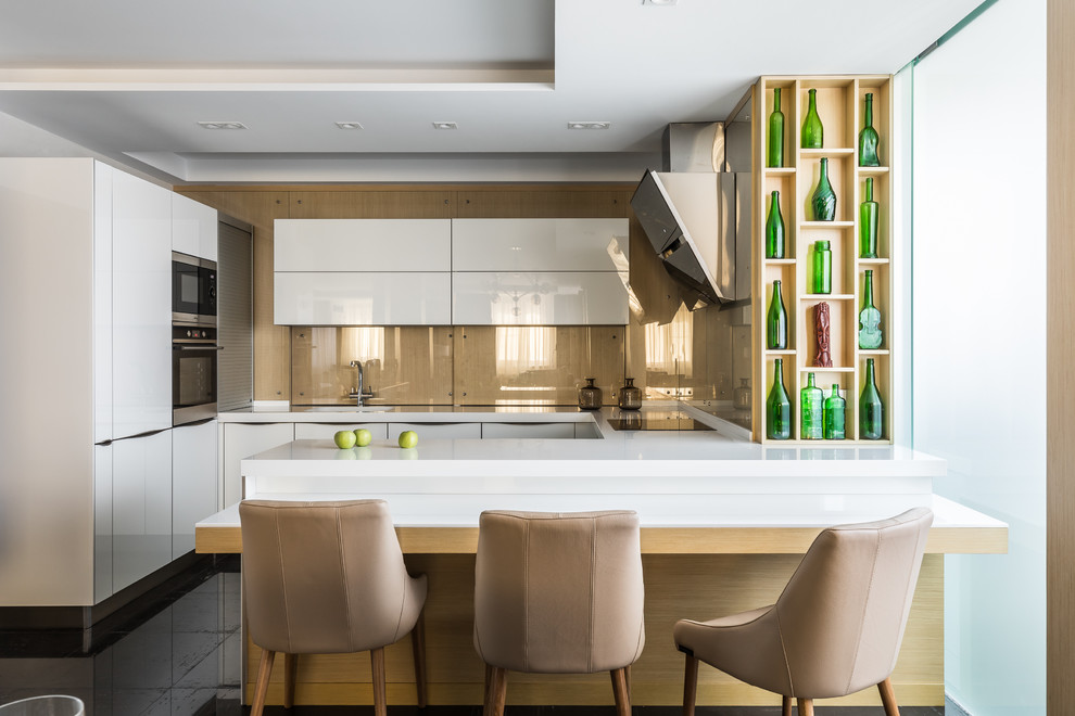 Design ideas for a contemporary u-shaped kitchen in Other with flat-panel cabinets, white cabinets, beige splashback, stainless steel appliances, a peninsula, black floor and glass sheet splashback.