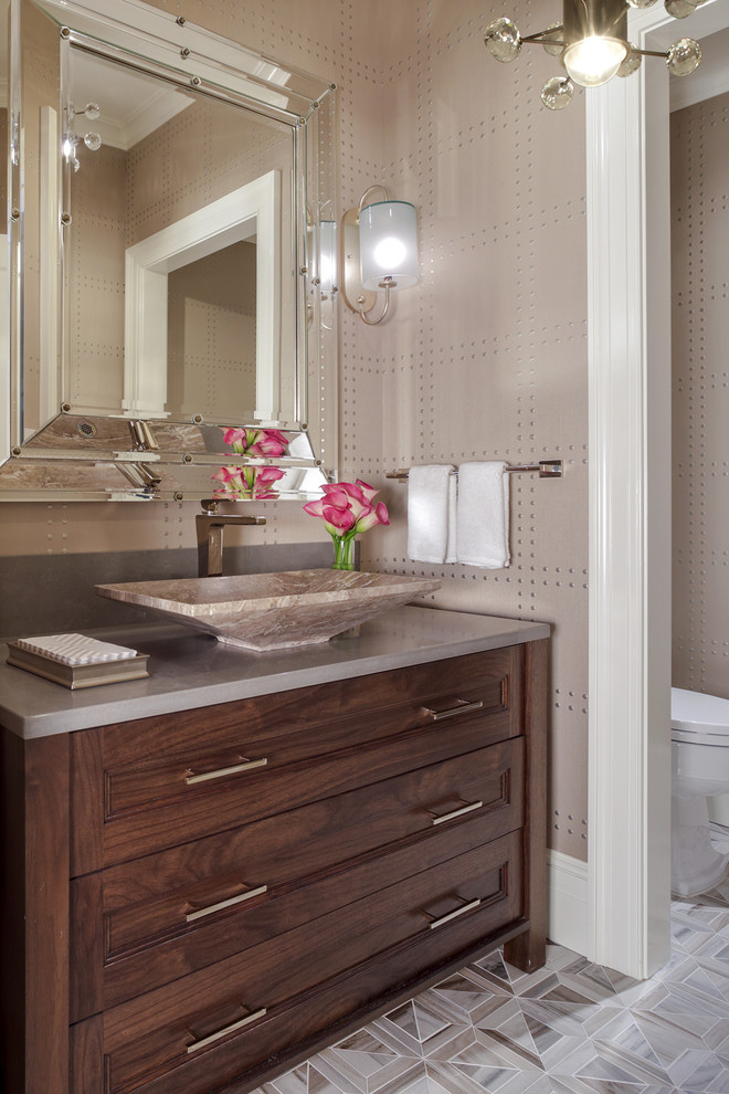 Inspiration for a large traditional powder room in New York with shaker cabinets, brown cabinets, beige walls, ceramic floors, a vessel sink, granite benchtops, beige floor and grey benchtops.